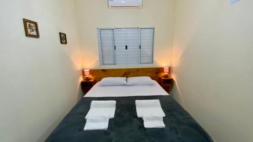 a small bedroom with a bed and a window at Suíte Lázaro in Ubatuba