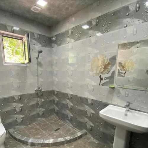 un baño con ducha y lavabo en Green Garden Garni, en Garni