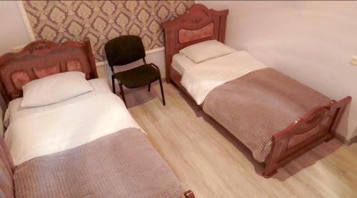 Una habitación con dos camas y una silla dentro. en Green Garden Garni, en Garni