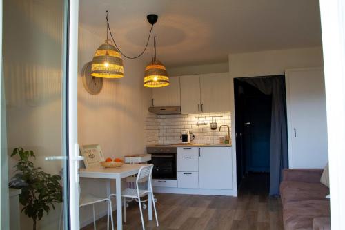 - une cuisine avec une table, des chaises et deux lumières dans l'établissement Le Ventoux, à Mollans-sur-Ouvèze