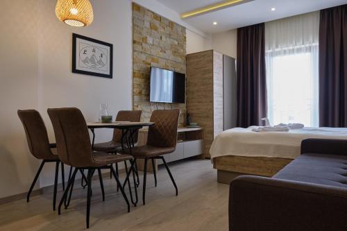 a hotel room with a bed and a table and chairs at L&N Apartmani Kopaonik-Milmari Resort in Kopaonik