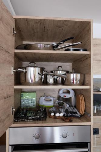 a kitchen with many pots and pans on shelves at L&N Apartmani Kopaonik-Milmari Resort in Kopaonik
