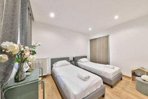 - une chambre avec 2 lits et une table fleurie dans l'établissement Cosy 2 Bedroom Flat 10min to the Vieux Port, à Marseille