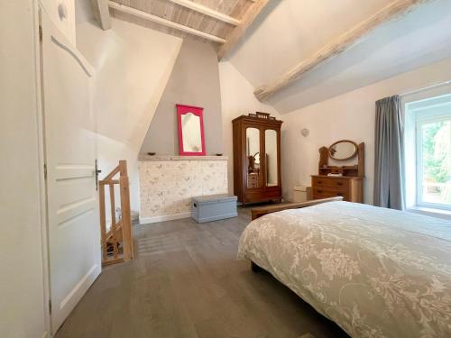 a bedroom with a bed and a dresser and a window at Maison De L'Etang in Essey