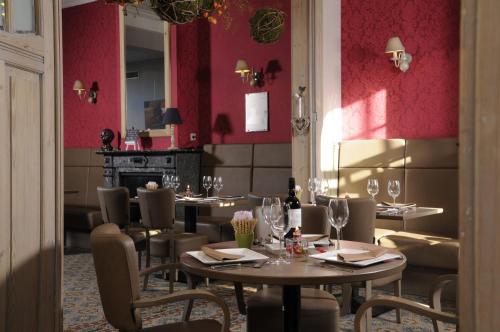 a restaurant with tables and chairs and red walls at Oud Gemeentehuis in Poelkapelle