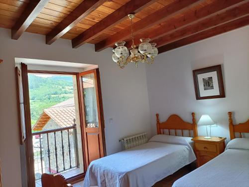 a bedroom with two beds and a balcony at Apartamentos rurales La Casa Vieja De Alceda in Alceda