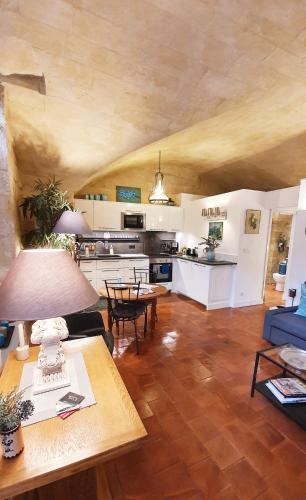 un salon avec une table et une cuisine dans l'établissement Appartement dans Hotel de Flaux, à Uzès