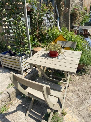 a wooden picnic table and a bench in a garden at Calcata - La Casa di Bianca in Calcata
