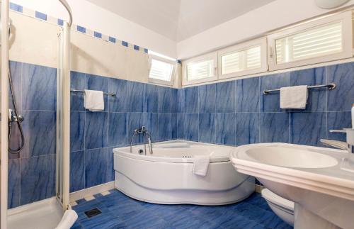 a bathroom with a tub and a toilet and a sink at vila ivan i ian in Stanići