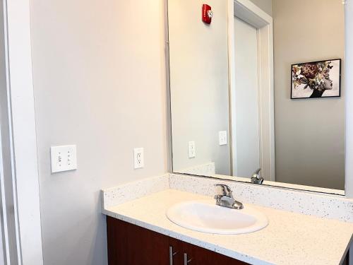 a bathroom with a sink and a large mirror at Porsch City Loft in Atlanta