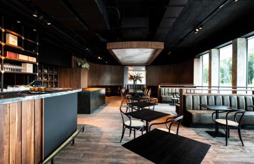 un restaurant avec des tables et des chaises ainsi qu'un bar dans l'établissement Parkhotel Waregem, à Waregem