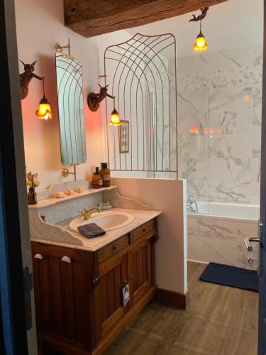 bagno con lavandino, vasca e specchio di Les Rêveries a Chazé-sur-Argos