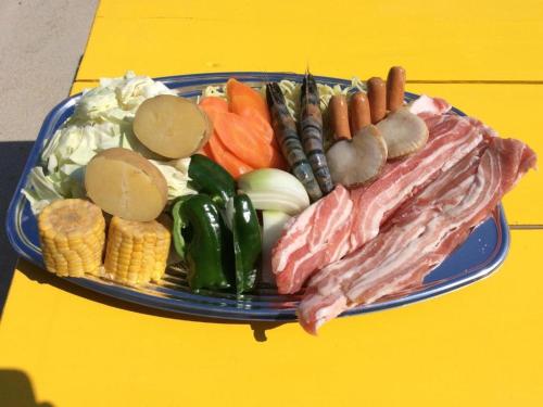 um prato de alimentos com carne e vegetais numa mesa amarela em Kunigami-gun - House - Vacation STAY 78177v em Higashi