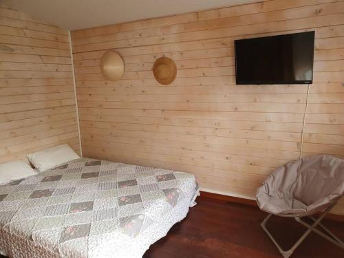 - une chambre avec un lit et une télévision à écran plat dans l'établissement Chalet Cosy, à Audenge