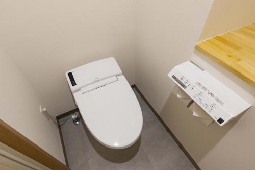 uma casa de banho com um WC branco num quarto em Mr.KINJO in Miegusuku em Naha