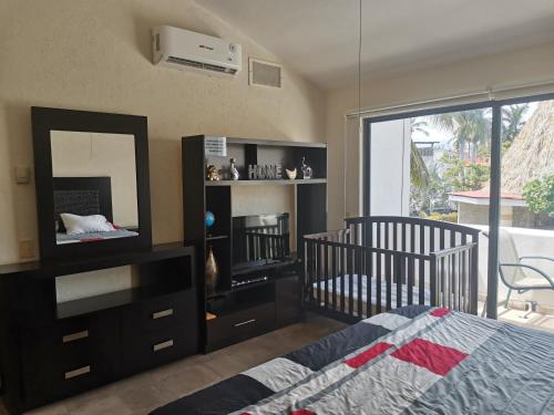 a bedroom with a crib and a mirror and a bed at Villa dentro del Hotel Vidanta Mayan Palace in Acapulco