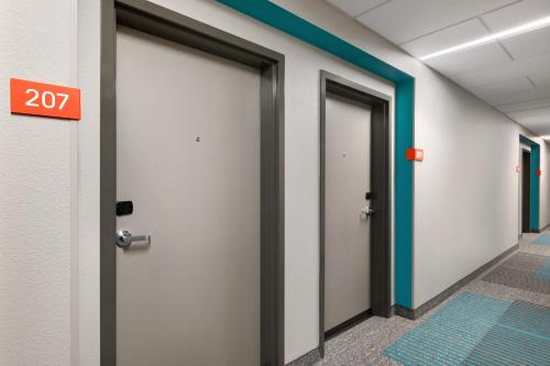 a row of doors in a hallway with a exit sign at avid hotels - Memphis - Southaven by IHG in Southaven