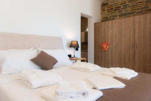 a white bed with white towels on top of it at Lazarou Beach Apartments in Platis Yialos Sifnos