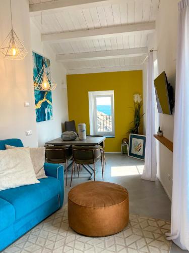 a living room with a blue couch and a table at La Ripa Camere Vernazza in Vernazza
