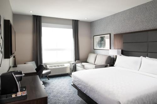 a hotel room with a large bed and a chair at Holiday Inn Express - Boston South - Quincy by IHG in Quincy