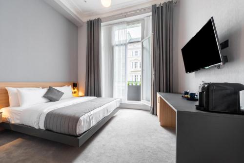 a bedroom with a bed and a flat screen tv at Gainsborough Hotel in London