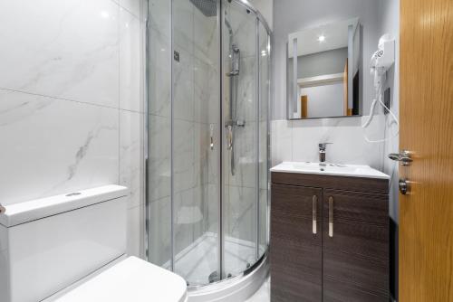 a bathroom with a shower and a toilet and a sink at Gainsborough Hotel in London