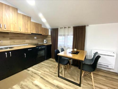 a kitchen with a table and chairs in a room at Clarina All Seasons Rooms & Apartments in Kruševo