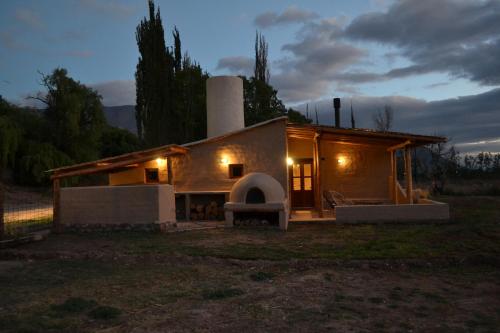 a small house with a fireplace in a field at Cabañas Sixilera in Huacalera