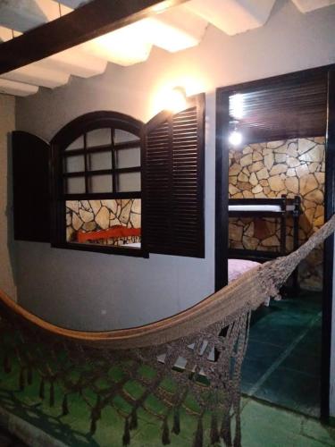 a room with a hammock hanging from a wall at Recanto da Iara in Arraial do Cabo