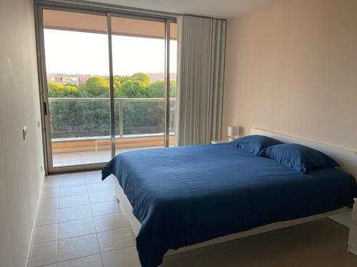 sypialnia z niebieskim łóżkiem i dużym oknem w obiekcie Herdade dos Salgados - Apartamento T2 w mieście Guia