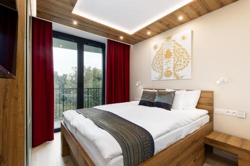 a bedroom with a large bed with red curtains at Araliya in Kraków