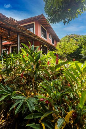 a house with a lot of plants in front of it at Flow Guest House in Salinópolis