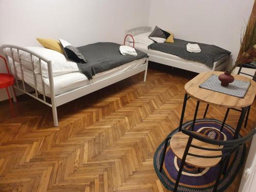 Moti Apartments في كراكوف: سريرين في غرفة ذات أرضيات خشبية