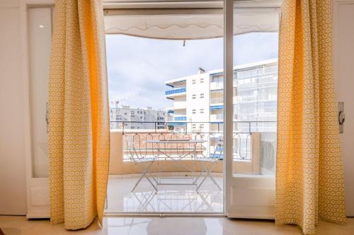 d'un balcon avec des rideaux et une vue sur un bâtiment. dans l'établissement 2Br 3 min from the center & the Croisette, à Cannes