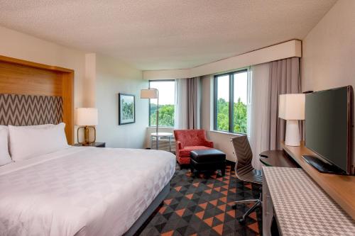 a hotel room with a bed and a flat screen tv at Holiday Inn Newport News - Hampton by IHG in Newport News