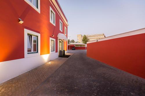 an empty alleyway between two orange buildings at Comtesse Lisbonne Guest House by Homing in Lisbon