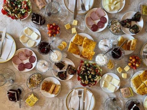 una mesa con platos de comida y copas de vino en Family Hotel Kolorit Old Tbilisi en Tiflis