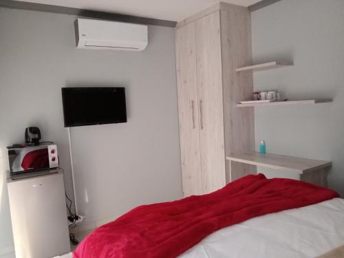a bedroom with a red blanket on a bed at Waterfall View Lodge in Midrand