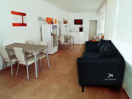 a living room with a couch and a table and chairs at Hotel Gran Córdoba in La Falda