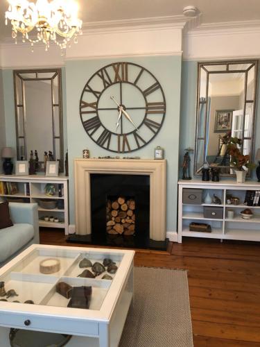 a living room with a large clock and a fireplace at Casa Amor in Great Yarmouth