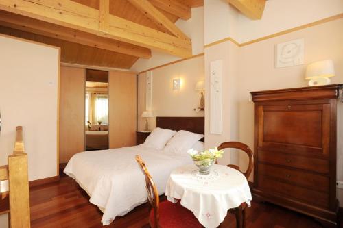 - une chambre avec un lit et une table avec un vase dans l'établissement Pavillon de Diane, à Prades