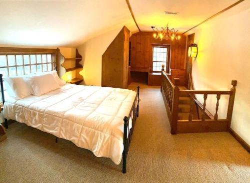 a bedroom with a large bed and a staircase at Beautiful in town acreage in Lincoln