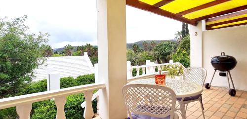 a porch with a table and chairs and a grill at Montagu Little Sanctuary - Hot Spring Access at Special Rate in Montagu