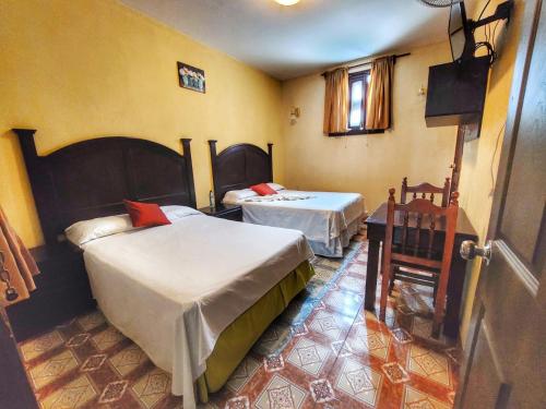 a bedroom with two beds in a room with a window at Hotel Santa Maria in Panajachel