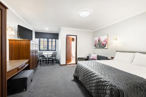 een hotelkamer met een bed en een bureau bij Adelaide Inn in Adelaide