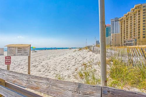 a beach with a wooden fence and a sign on it at Phoenix Vacation Rentals in Orange Beach
