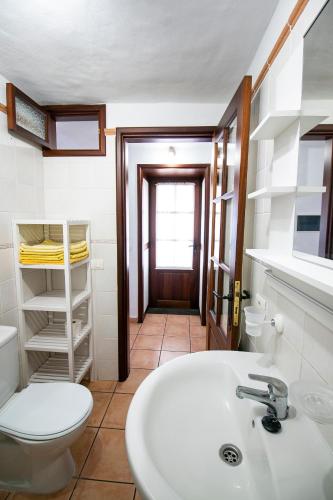 a bathroom with a white sink and a toilet at Casas los Alisios II in Los Quemados