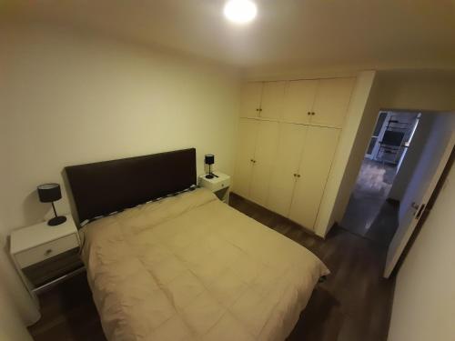 1 dormitorio con 1 cama grande y 2 mesitas de noche en Departamento Centrico en Rosario