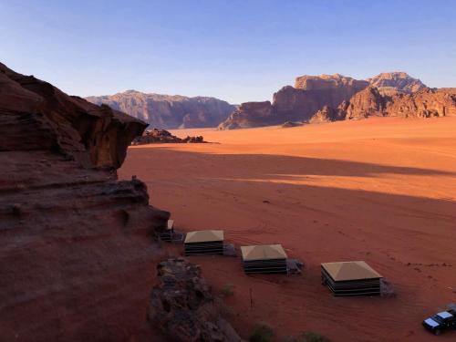 a view of a desert with three tents in the foreground at Milky Way Bedouin Camp in Wadi Rum