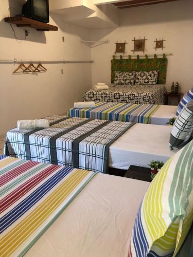a group of three beds in a room at Pousada Nascer do Sol in Marau